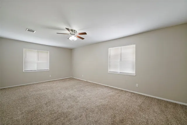 an empty room with a window and a ceiling fan