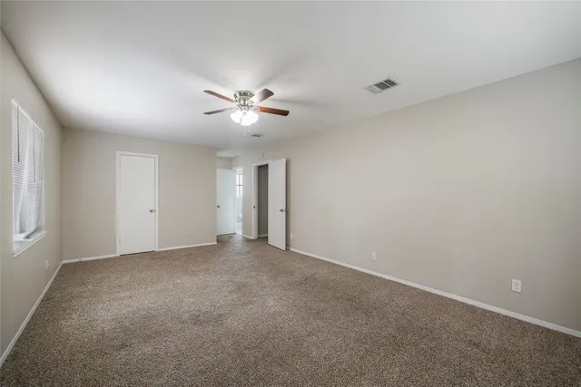 an empty room with a empty space and a ceiling fan