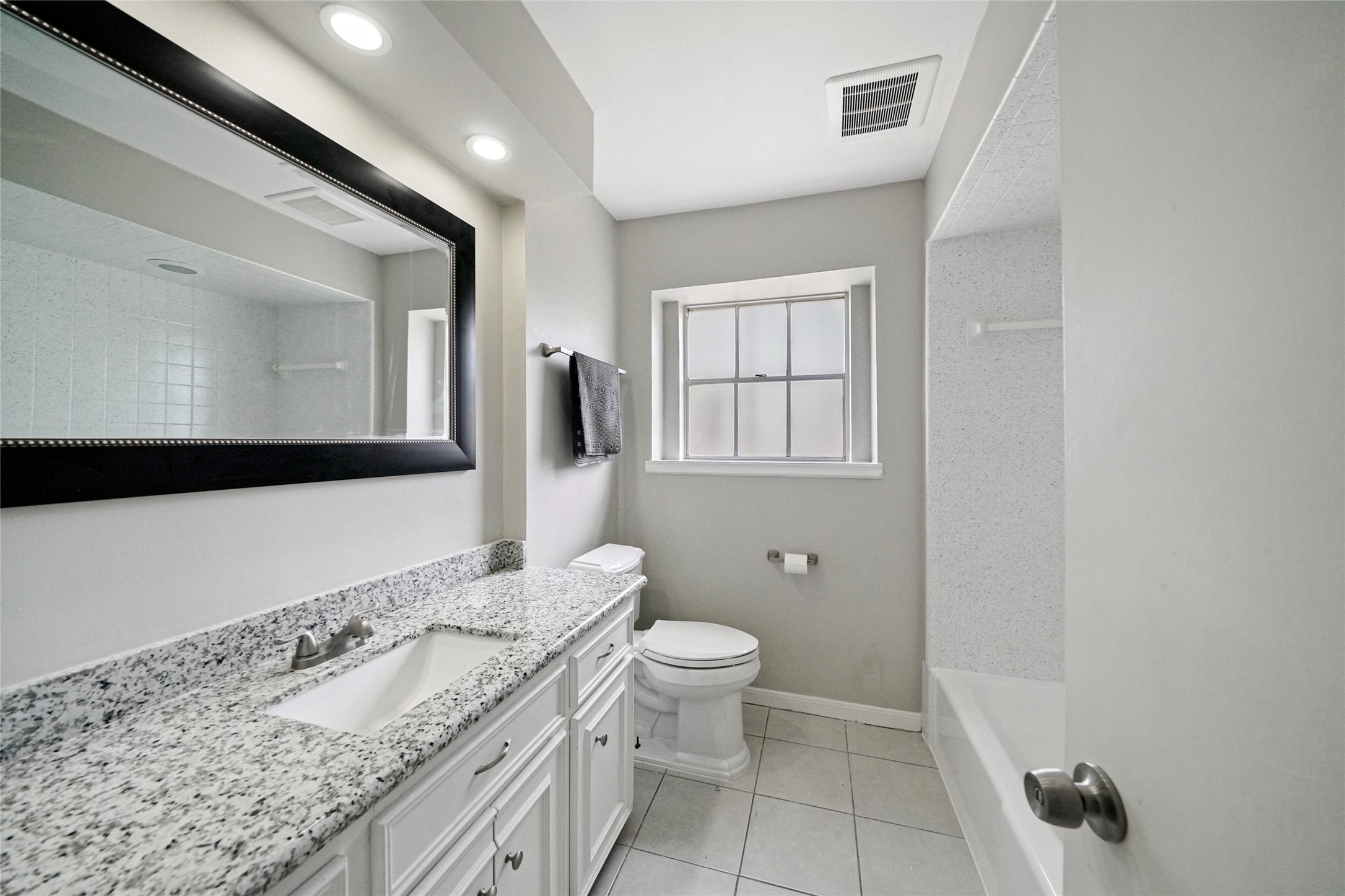 643 Ames Street Spring, TX 77373 - Photo 27 of 32 a spacious bathroom with a granite countertop sink a toilet and a mirror