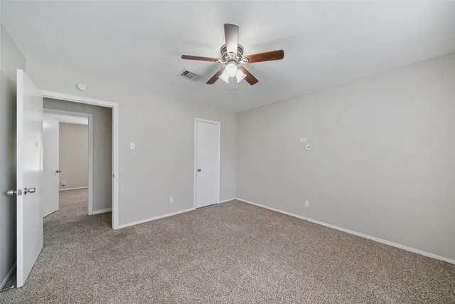 an empty room with chandelier fan