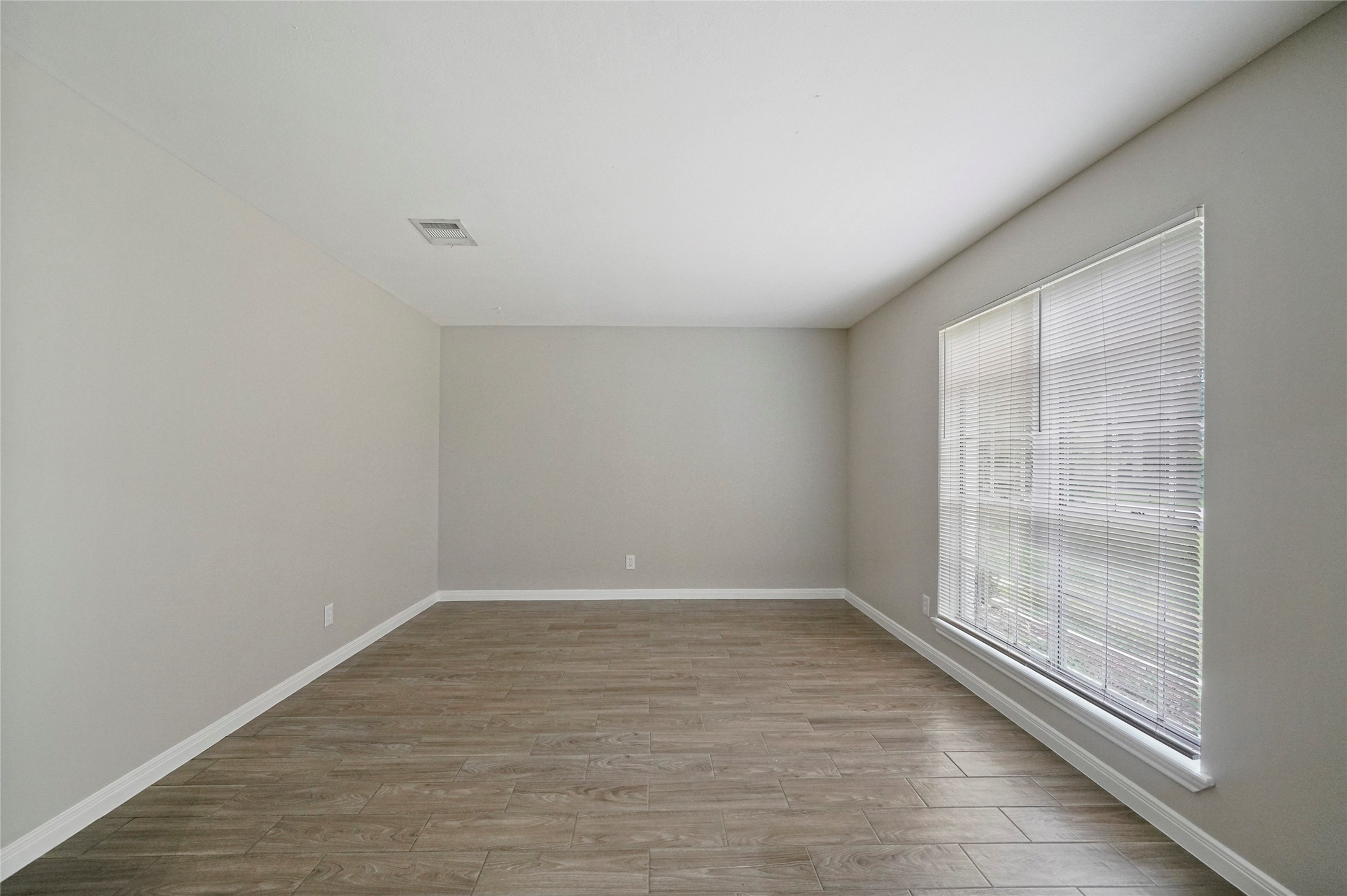 643 Ames Street Spring, TX 77373 - Photo 6 of 32 a view of an empty room with wooden floor and a window