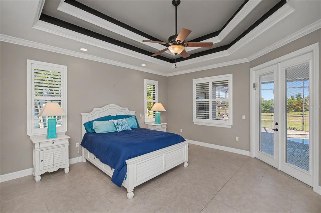 1736 Suzi Street Punta Gorda, FL 33950 - Photo 34 of 80 a bedroom with a large bed chandelier and a window