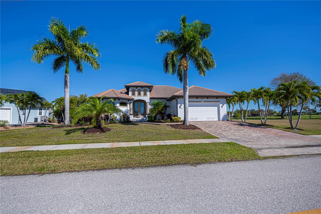 1736 Suzi Street Punta Gorda, FL 33950 - Photo 4 of 80 a front view of a house with a yard and palm trees
