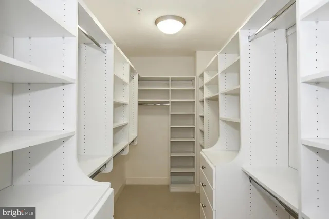 a view of walk in closet with empty racks