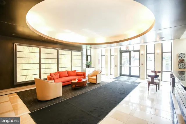 a living room with furniture and floor to ceiling windows