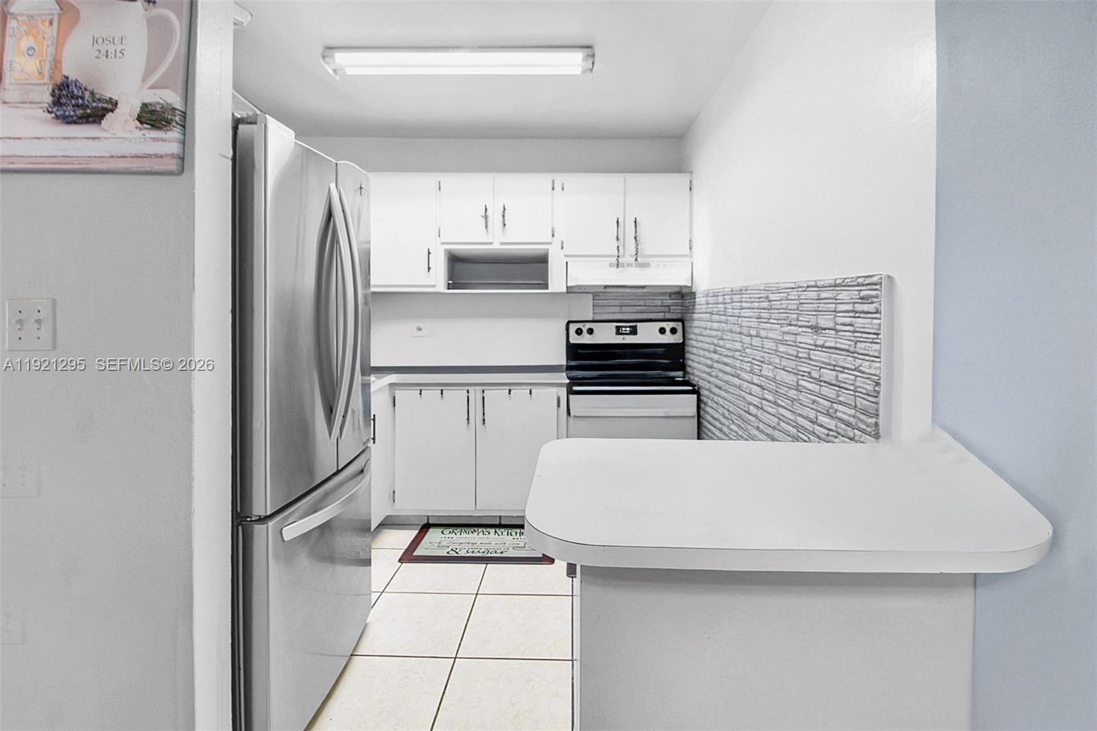 10745 Southwest 3rd Street, Unit 6 Sweetwater, FL 33174 - Photo 11 of 17 a kitchen with stainless steel appliances a refrigerator and a stove top oven