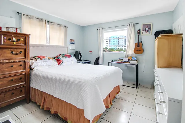 a bed room with a bed and a white kitchen