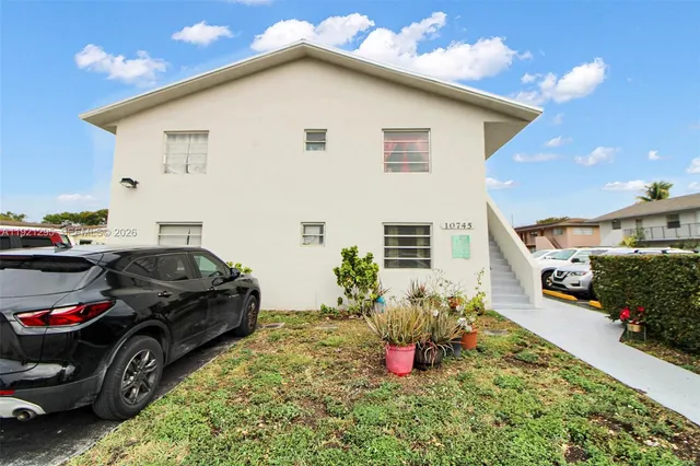 a view of a white house and a yard
