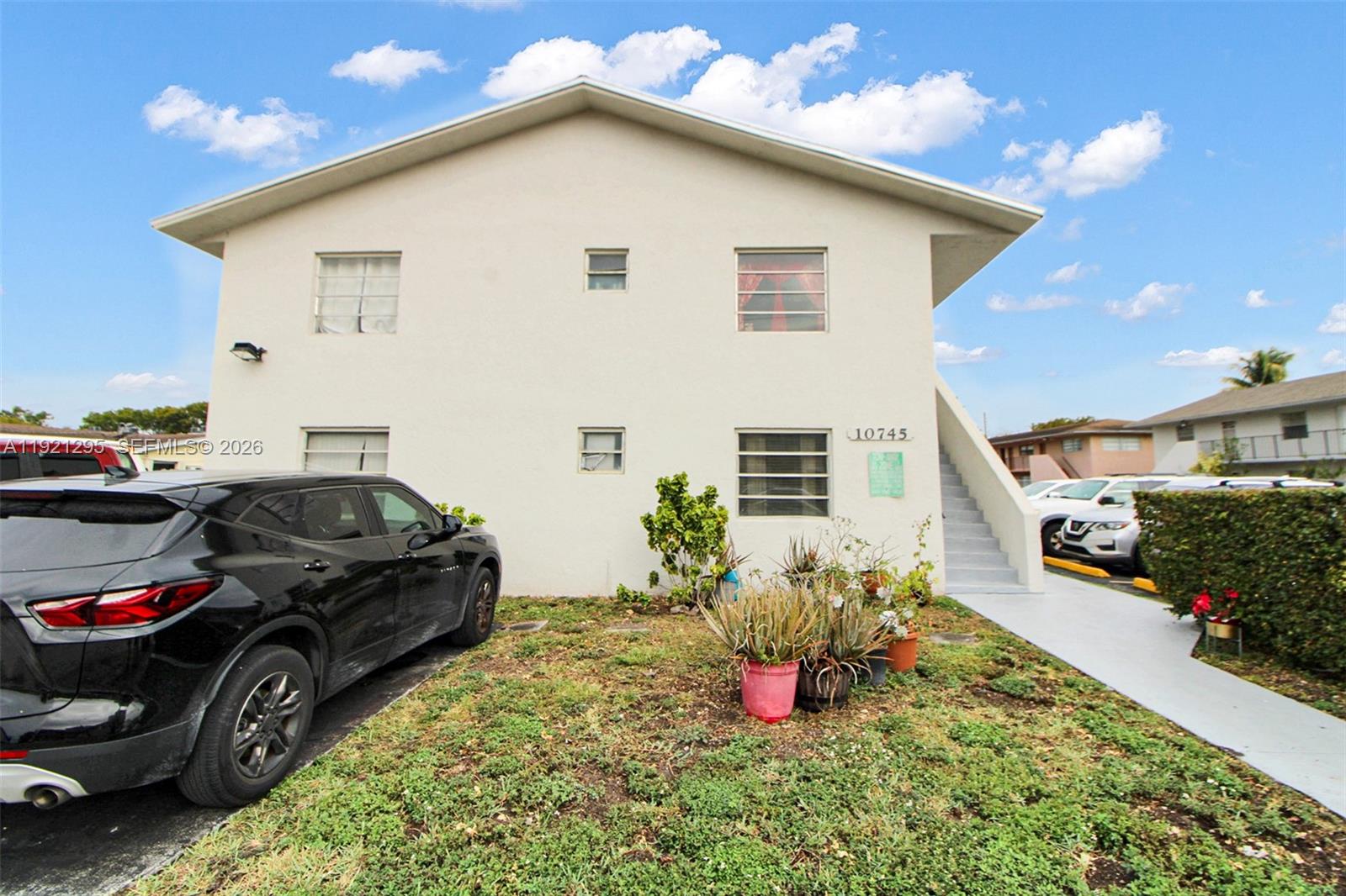 10745 Southwest 3rd Street, Unit 6 Sweetwater, FL 33174 - Photo 2 of 17 a view of a white house and a yard