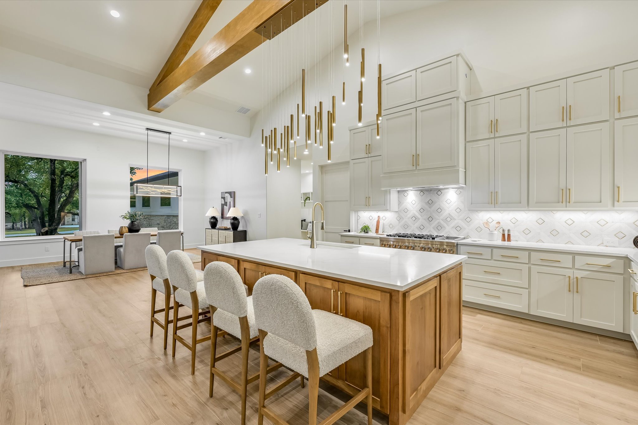 410 Shady Tree Drive Georgetown, TX 78633 - Photo 11 of 40 Kitchen featuring a kitchen island with sink, light wood-style floors, a kitchen breakfast bar, decorative light fixtures, and dual tone cabinets