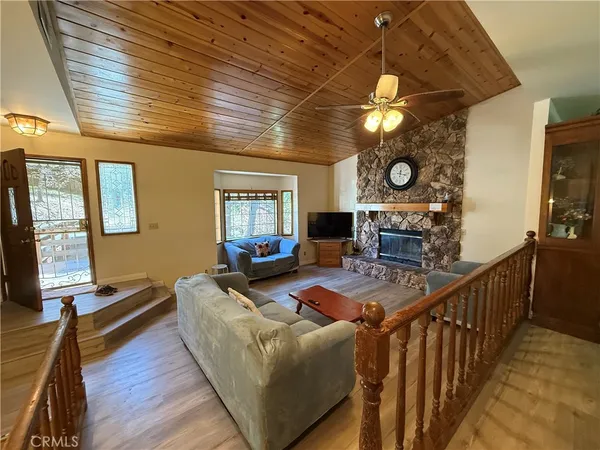 a living room with furniture a flat screen tv and a clock