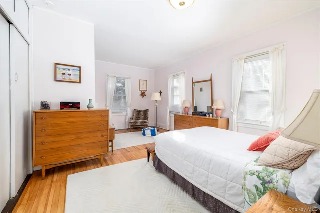 a bedroom with a bed and dresser with mirror