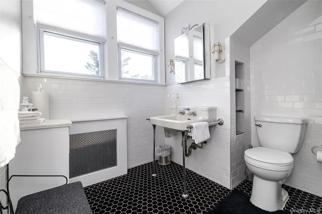 a bathroom with a sink toilet and window