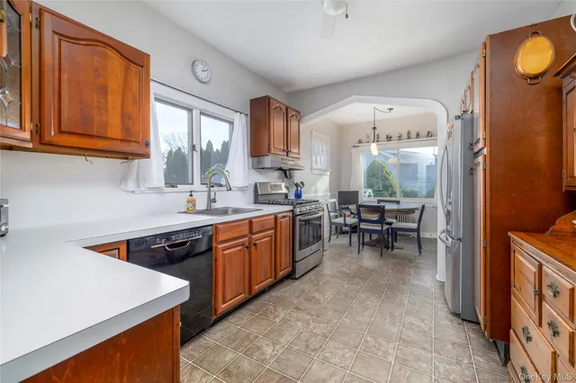 a kitchen with stainless steel appliances granite countertop sink stove top oven and cabinets