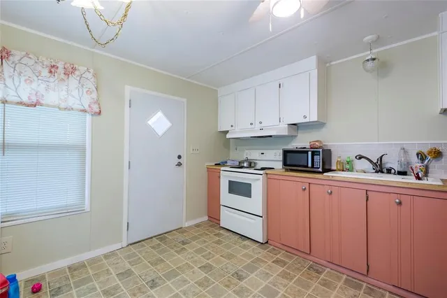 a kitchen with granite countertop white cabinets and white appliances