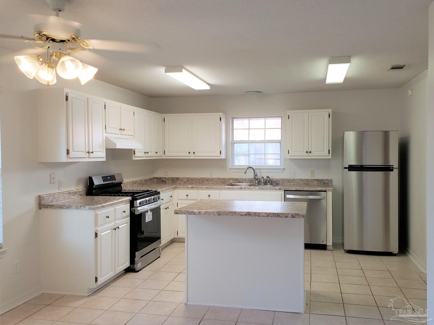 1767 Condor Drive Cantonment, FL 32533 - Photo 4 of 14 a kitchen with stainless steel appliances granite countertop a stove a sink a refrigerator and white cabinets