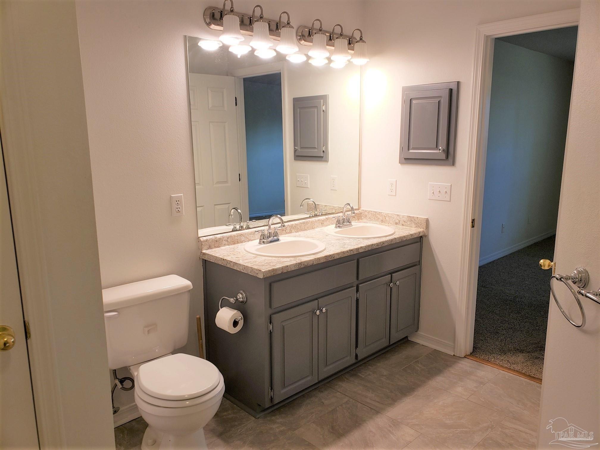 1767 Condor Drive Cantonment, FL 32533 - Photo 8 of 14 a bathroom with a sink a toilet and mirror