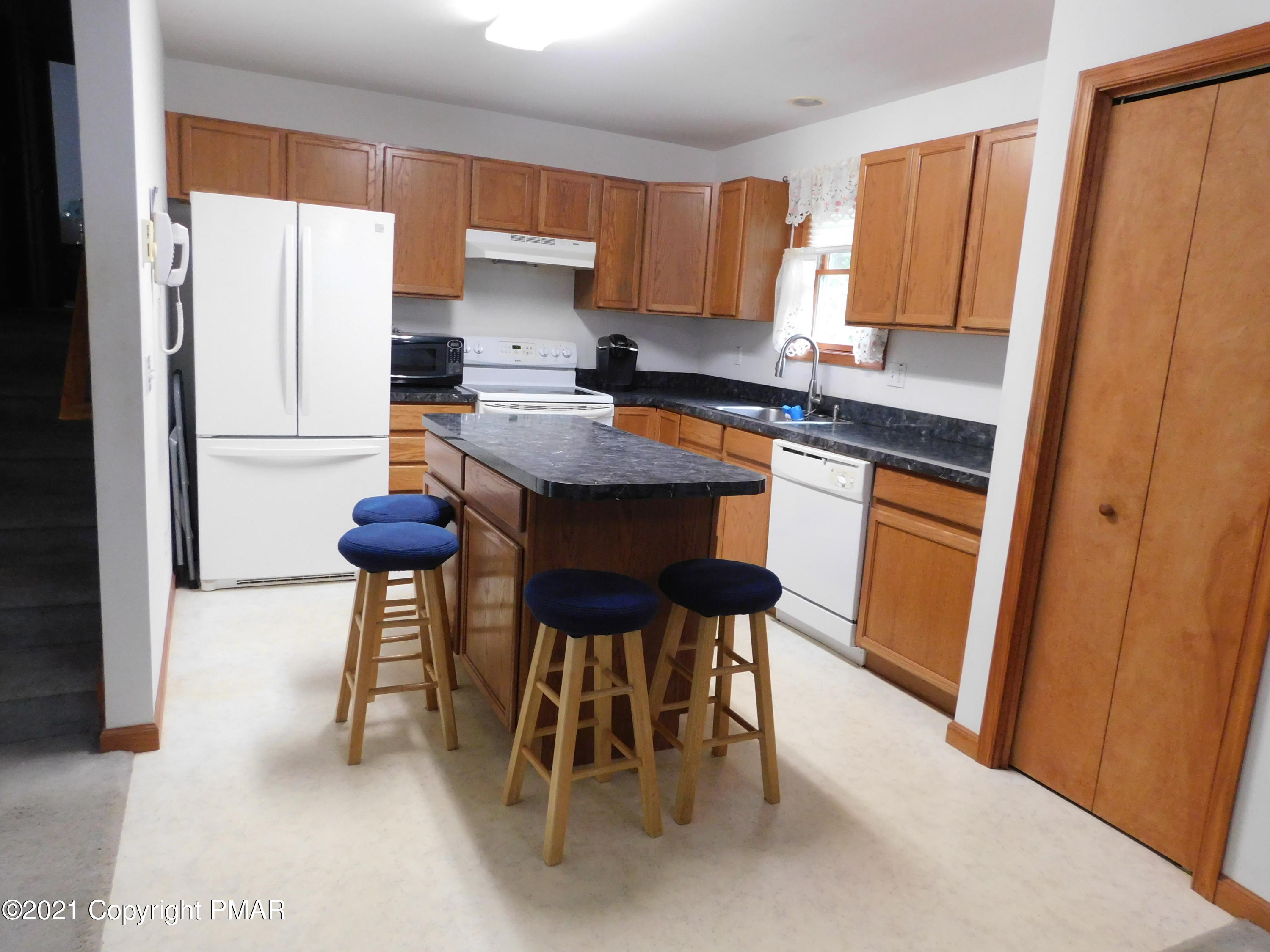 1051 Hampstead Road Bushkill, PA 18324 - Photo 17 of 40 a kitchen with granite countertop wooden cabinets a sink a stove a dining table and chairs