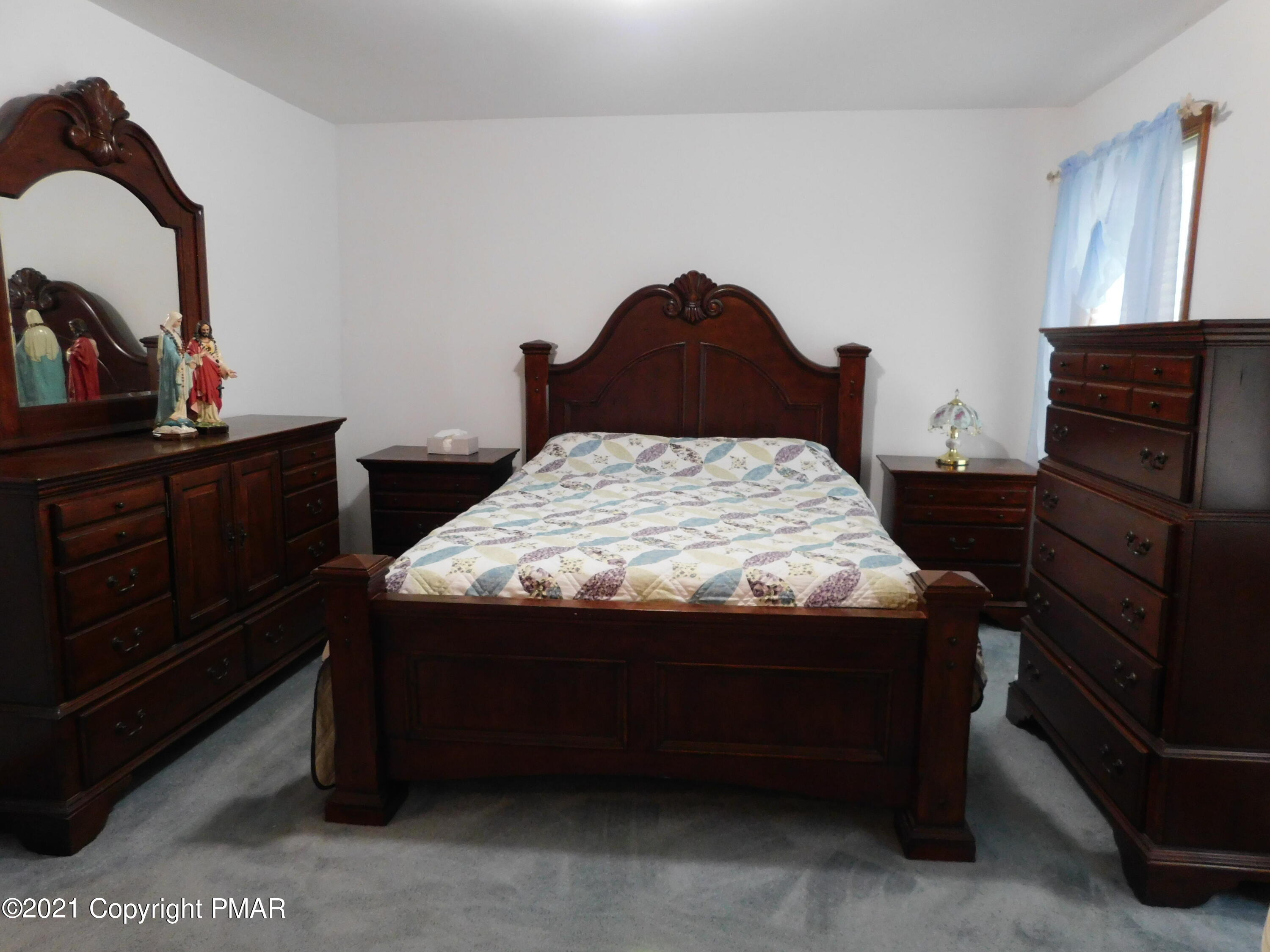 1051 Hampstead Road Bushkill, PA 18324 - Photo 22 of 40 a bed sitting in a bedroom next to a dresser next to a window