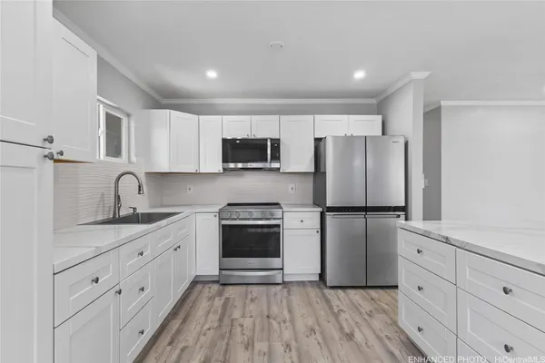 a kitchen with kitchen island a refrigerator stove microwave and cabinets