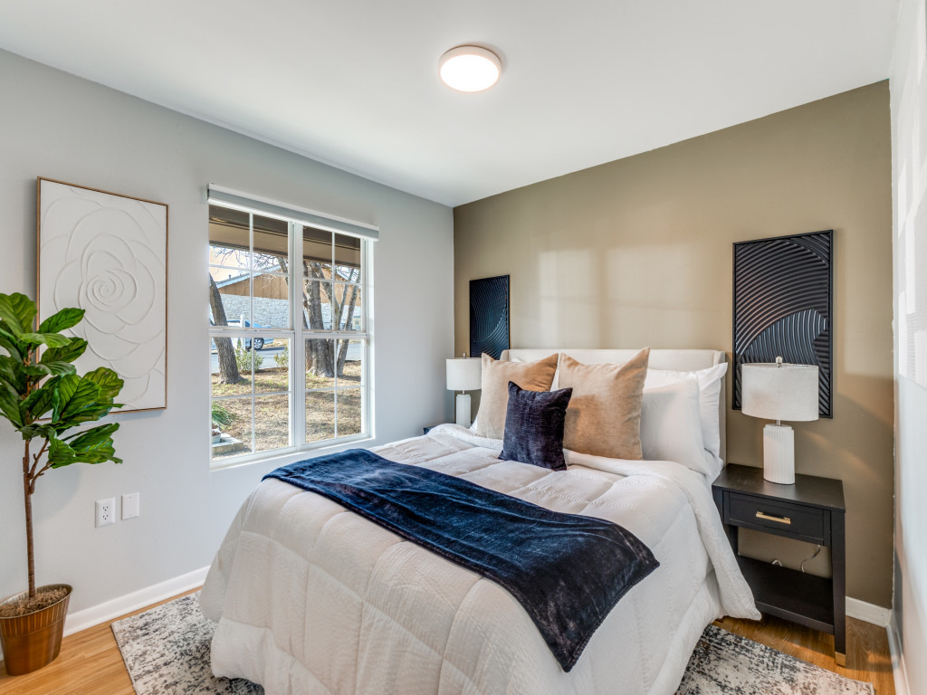 1705 Adriane Drive Austin, TX 78721 - Photo 11 of 31 a bedroom with a bed and a potted plant