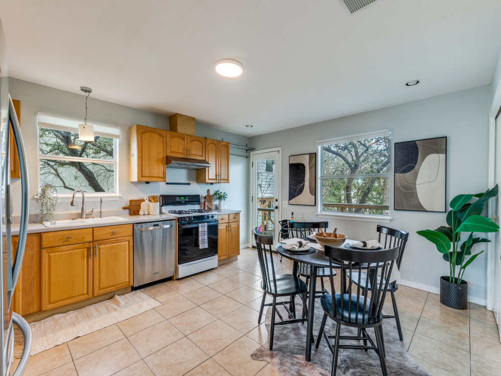 1705 Adriane Drive Austin, TX 78721 - Photo 4 of 31 a kitchen with stainless steel appliances granite countertop a stove top oven a sink a dining table and chairs