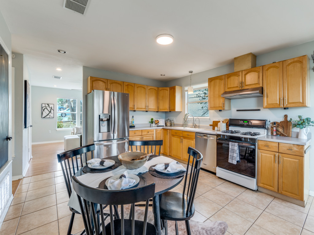 1705 Adriane Drive Austin, TX 78721 - Photo 5 of 31 a kitchen with stainless steel appliances granite countertop a stove a sink a microwave a dining table and chairs