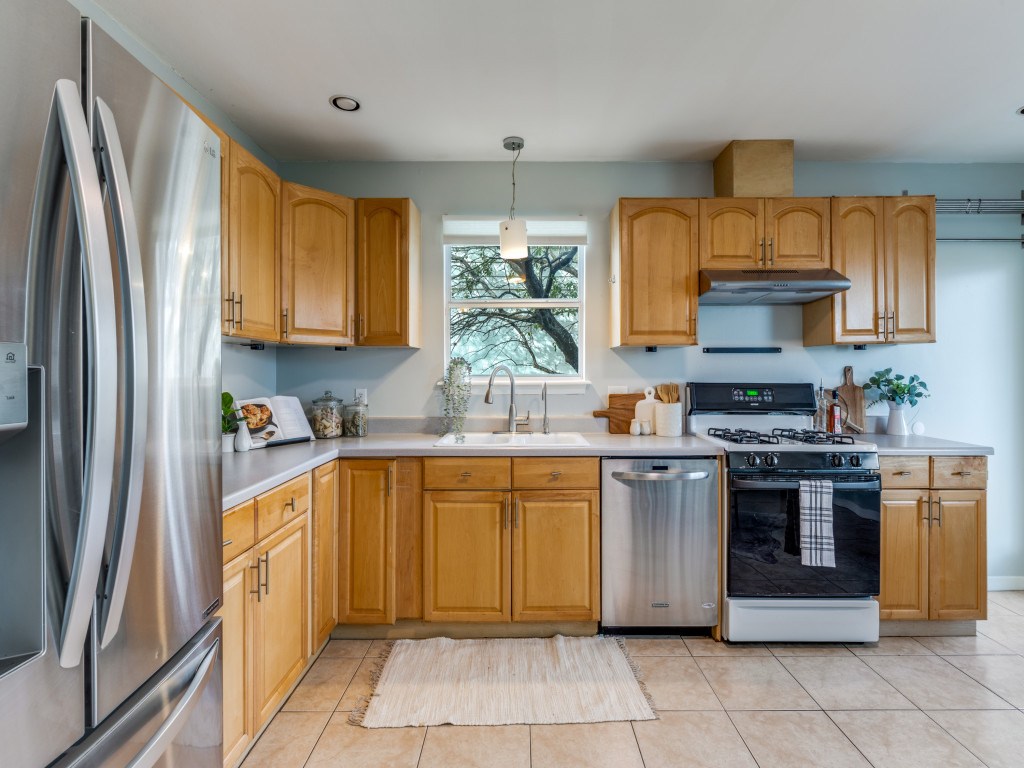 1705 Adriane Drive Austin, TX 78721 - Photo 7 of 31 a kitchen with stainless steel appliances granite countertop a stove a sink and a refrigerator