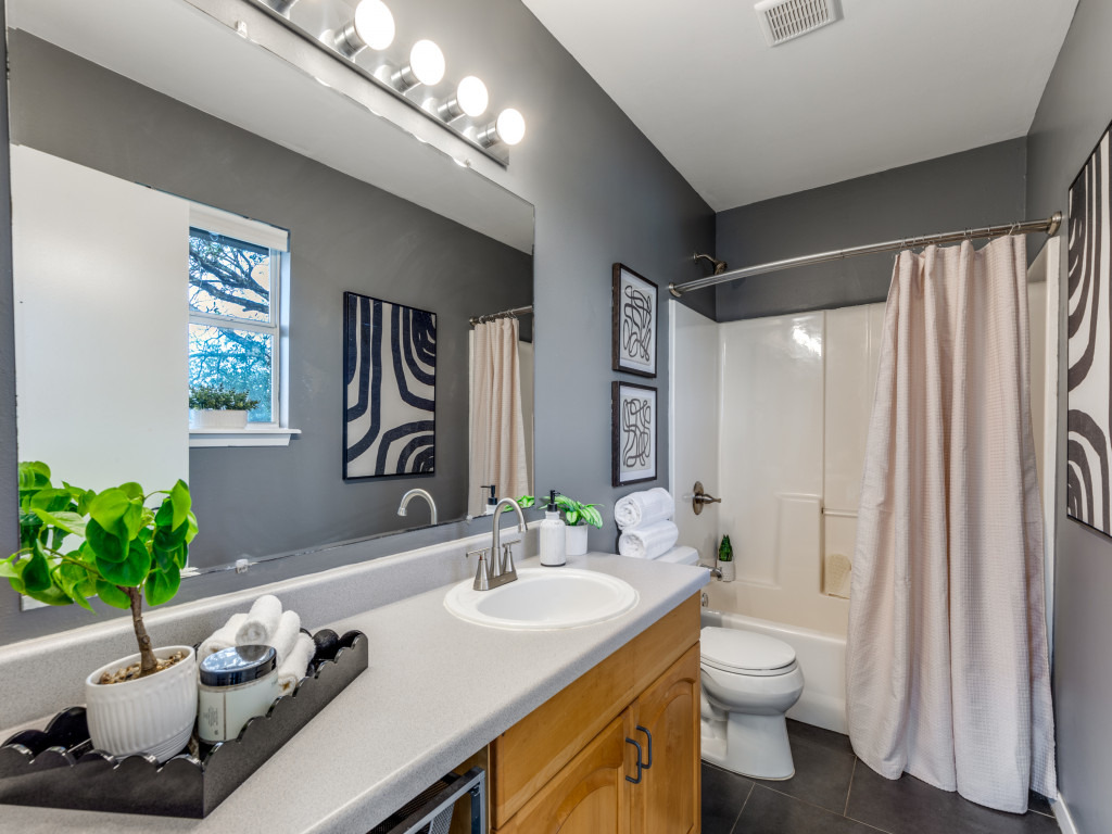 1705 Adriane Drive Austin, TX 78721 - Photo 10 of 31 a bathroom with a granite countertop sink a toilet and a mirror