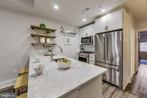 a kitchen with stainless steel appliances a refrigerator a sink and a stove
