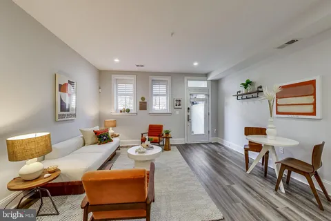 a living room with furniture and a wooden floor