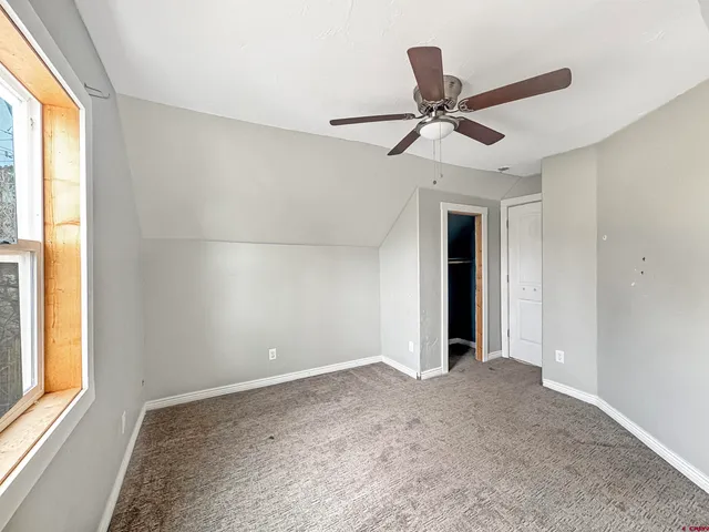 a view of a livingroom with a ceiling fan and window