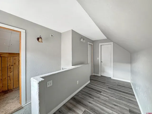 a view of a hallway with wooden floor and staircase