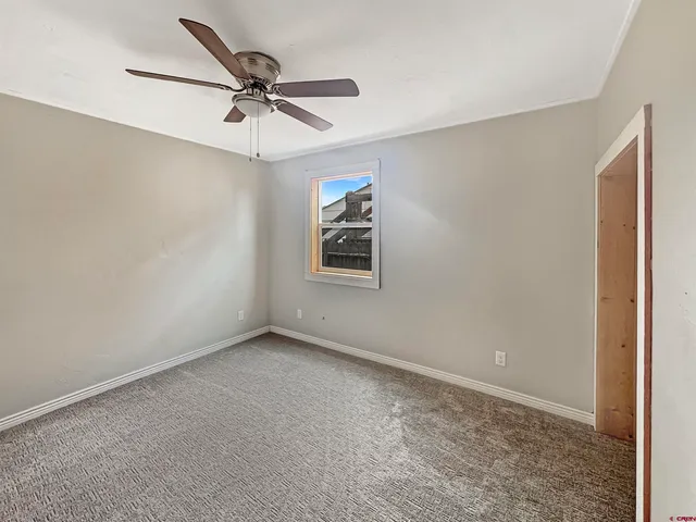 an empty room with a window and a fan