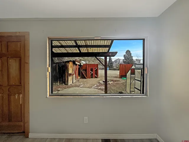 a view of a hallway with wooden floor and a bookshelf