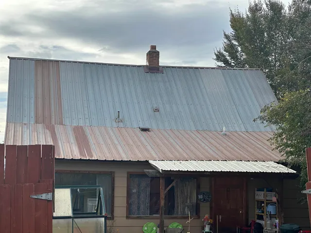 a view of a house with a yard patio and wooden fence