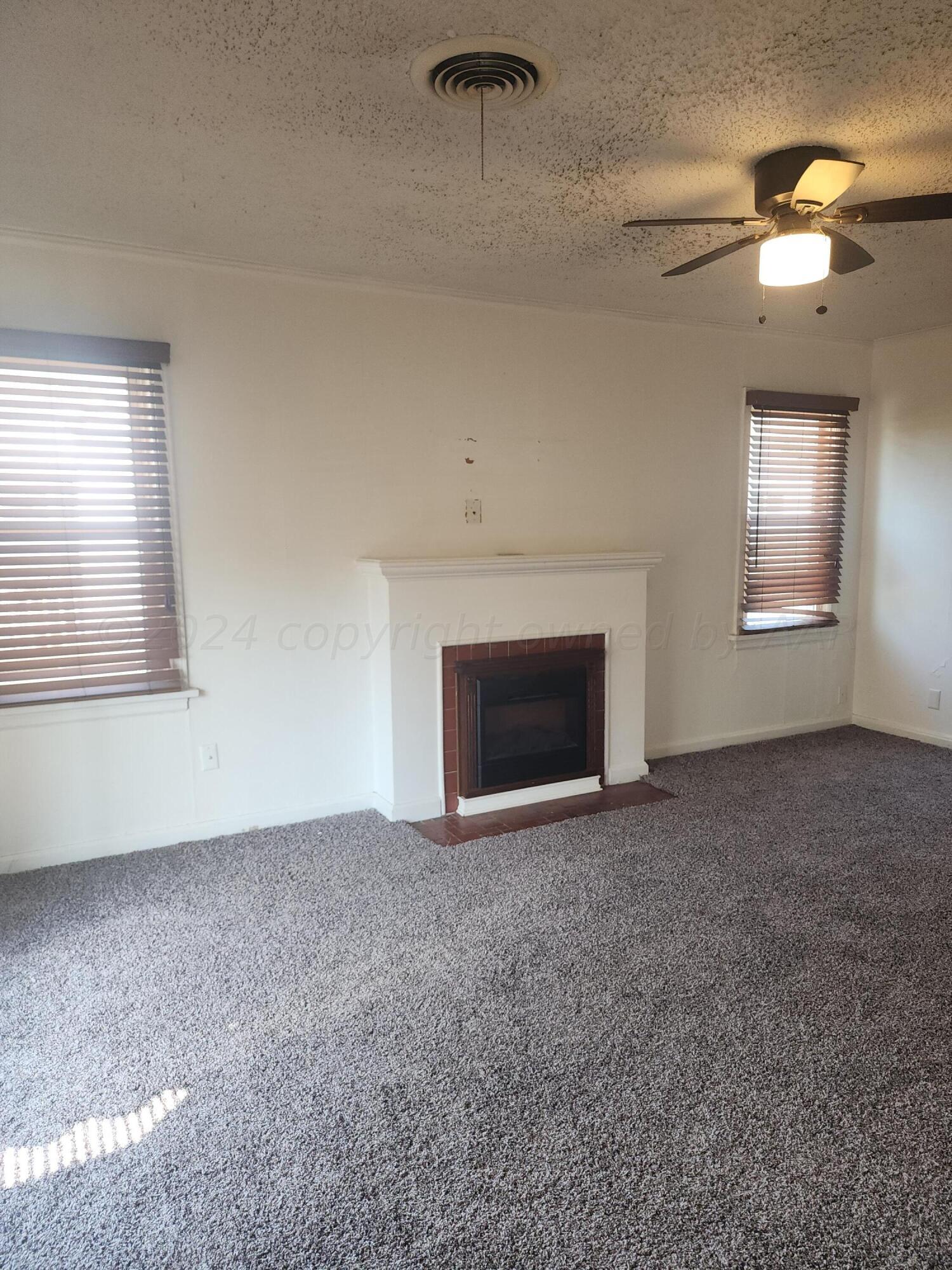 911 South Rusk Street Amarillo, TX 79102 - Photo 3 of 16 an empty room with windows and fireplace