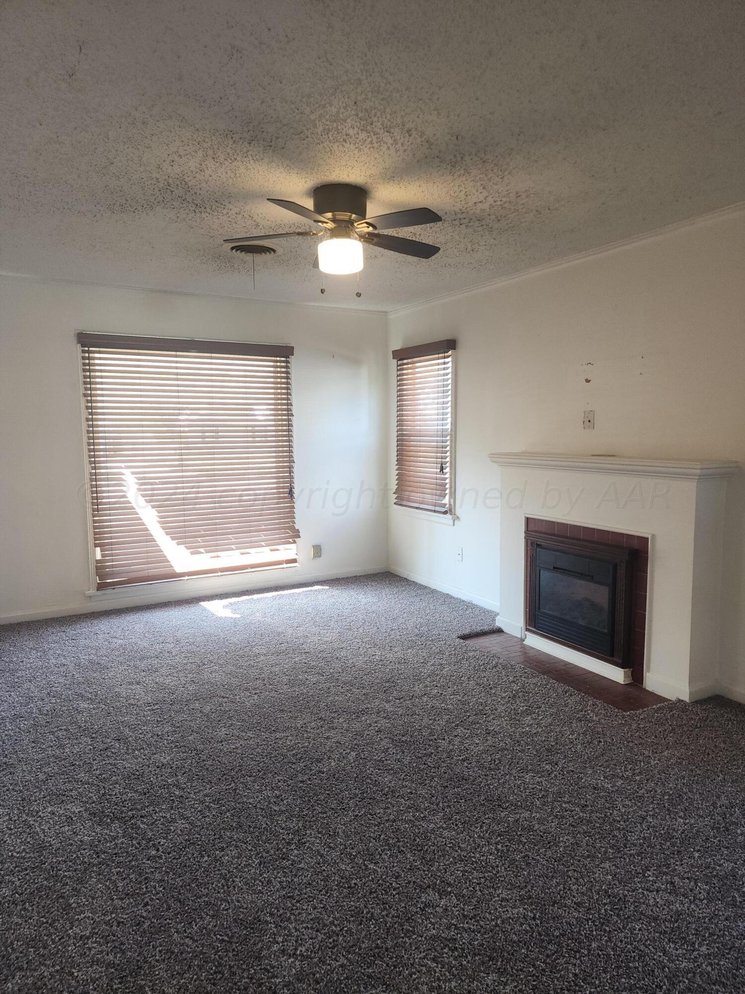 911 South Rusk Street Amarillo, TX 79102 - Photo 4 of 16 an empty room with windows and fireplace