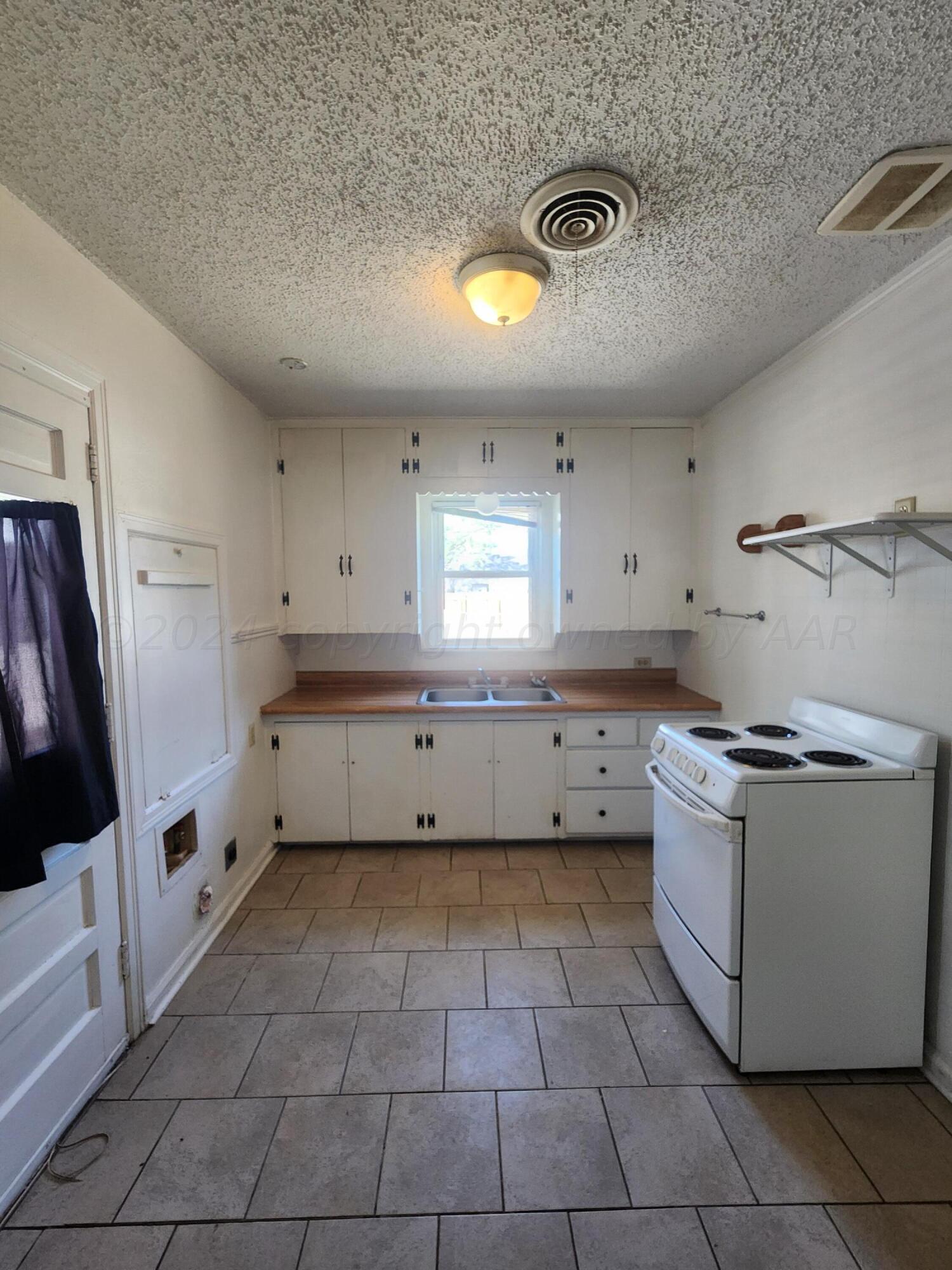 911 South Rusk Street Amarillo, TX 79102 - Photo 6 of 16 a kitchen with a stove a refrigerator and a sink