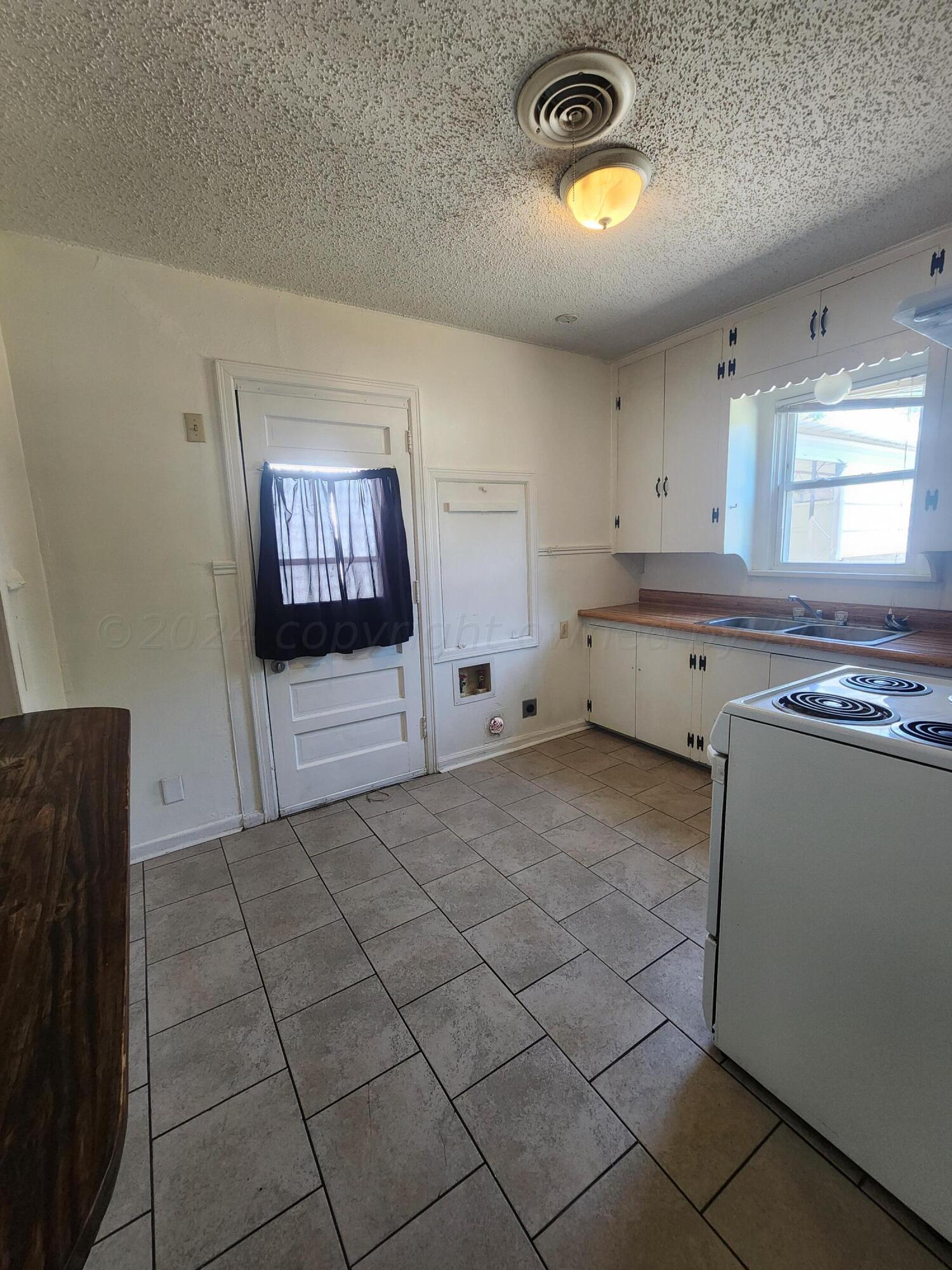 911 South Rusk Street Amarillo, TX 79102 - Photo 7 of 16 a kitchen with stainless steel appliances granite countertop a stove a sink and a refrigerator