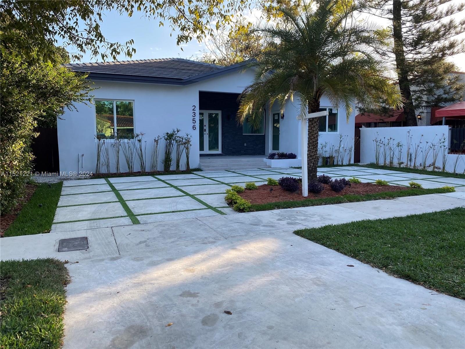 a front view of a house with a yard garage and outdoor seating
