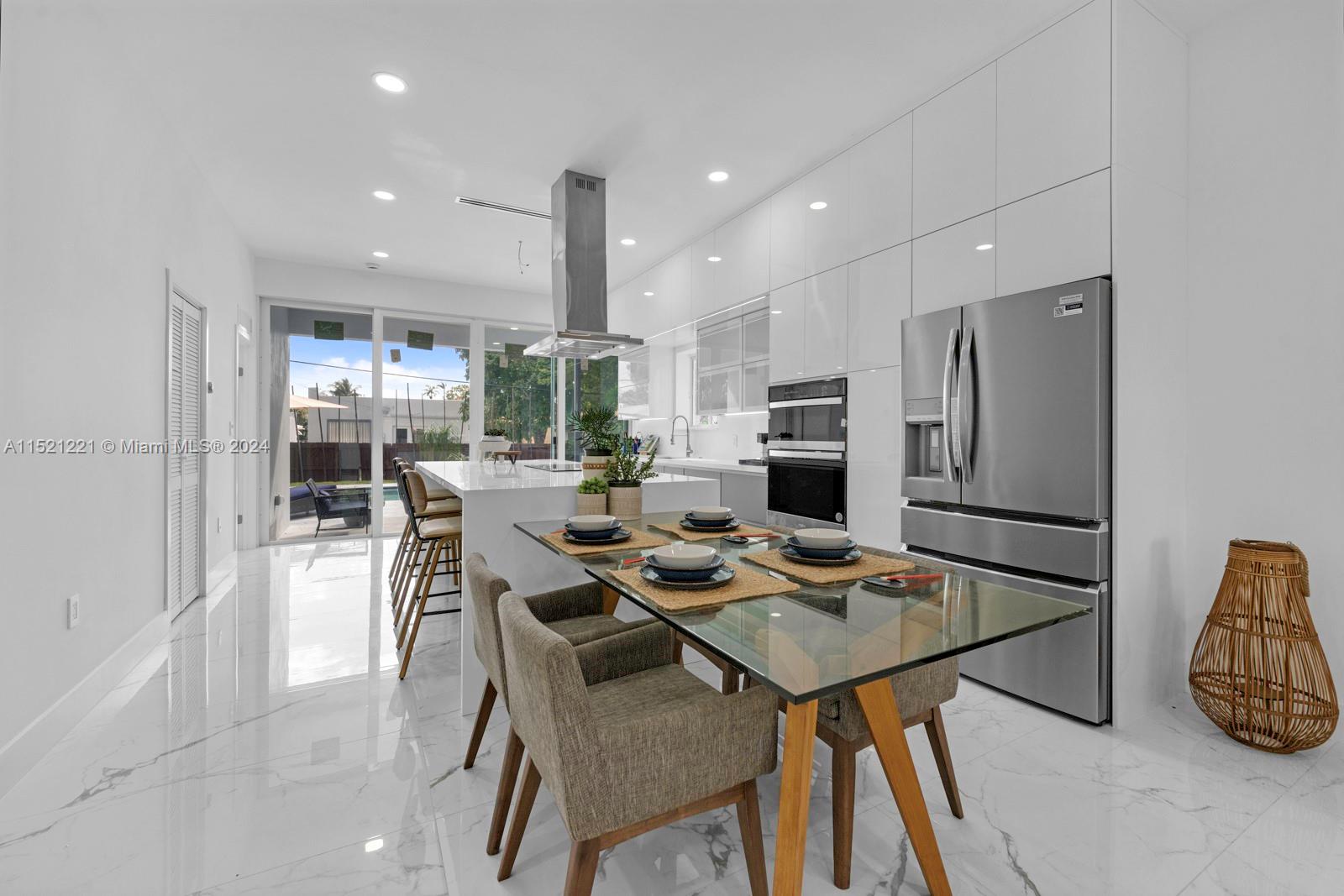 2356 Southwest 11th Street Miami, FL 33135 - Photo 14 of 51 a kitchen with stainless steel appliances granite countertop a table chairs and a refrigerator