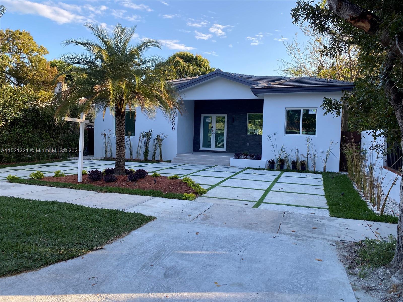 2356 Southwest 11th Street Miami, FL 33135 - Photo 2 of 51 a front view of a house with a yard and potted plants