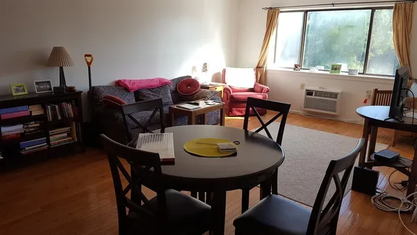 a view of a dining room with furniture and a potted plant