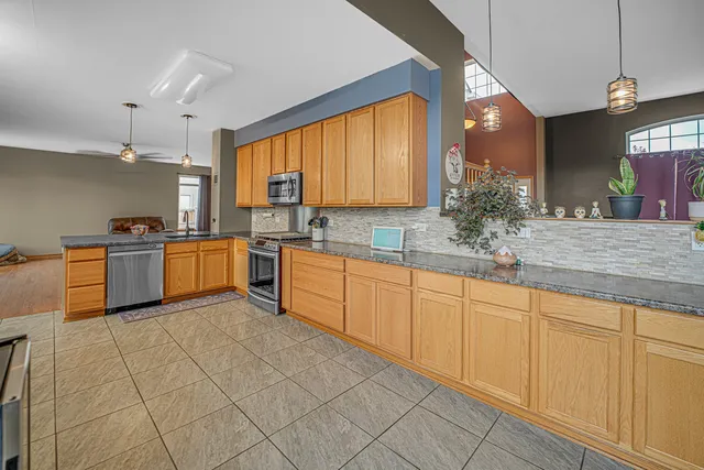 a kitchen with kitchen island granite countertop furniture a sink a counter and appliances