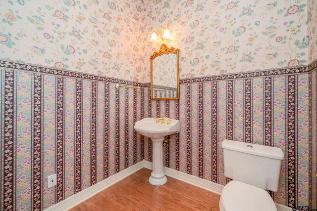 a bathroom with a toilet a sink and a shower curtain