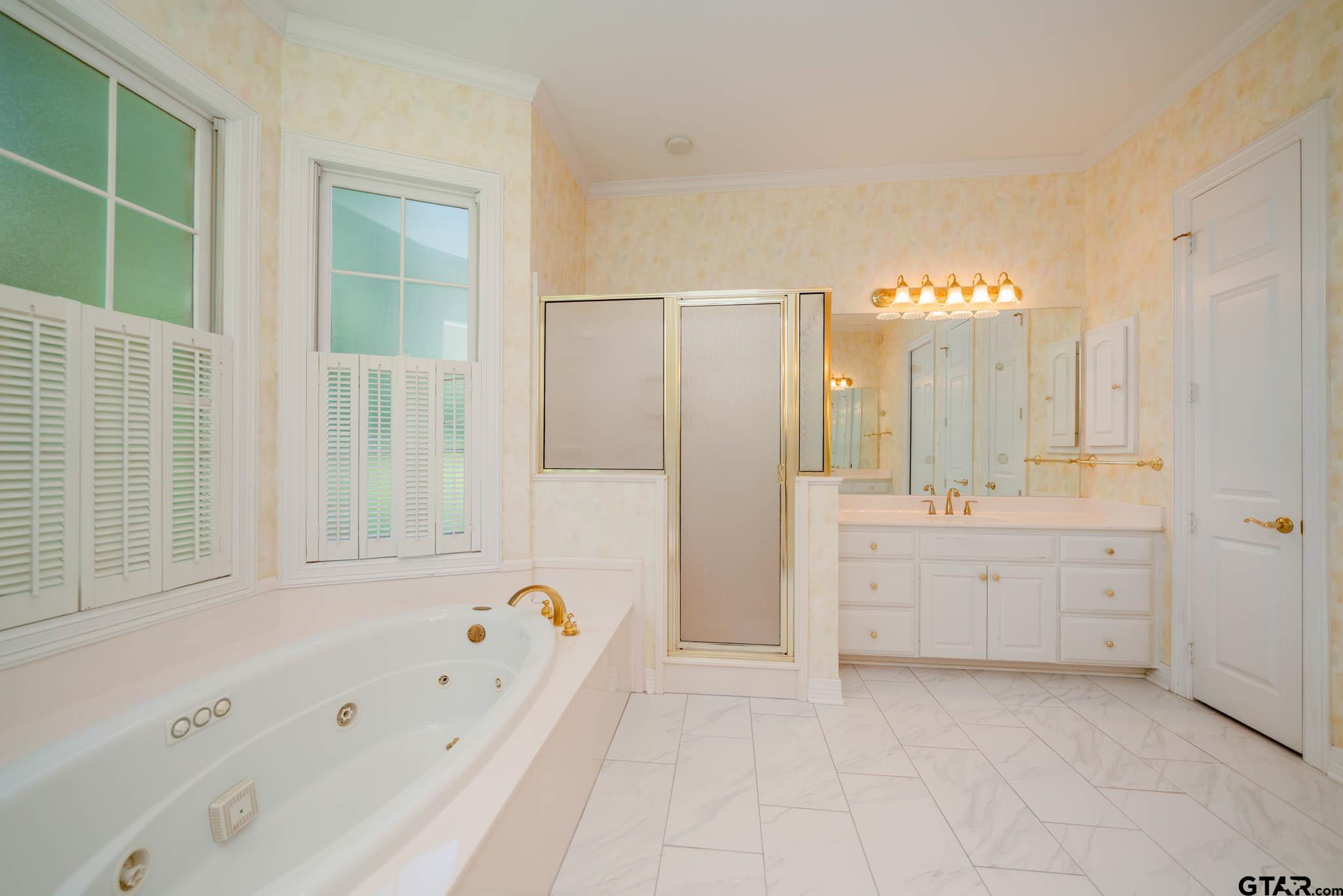 7 Summer Creek Way Longview, TX 75604 - Photo 25 of 48 a bathroom with a bathtub a sink and a window