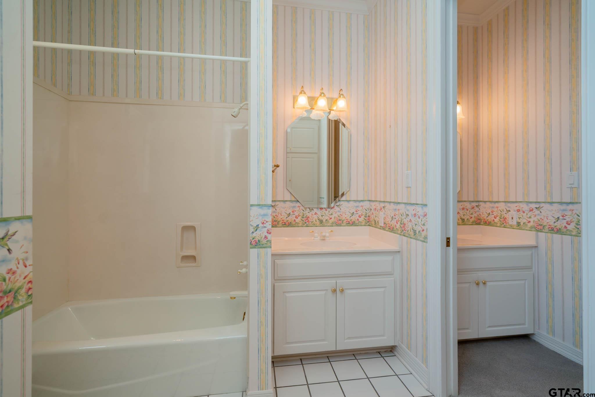 7 Summer Creek Way Longview, TX 75604 - Photo 31 of 48 a bathroom with a bathtub sink vanity and a mirror