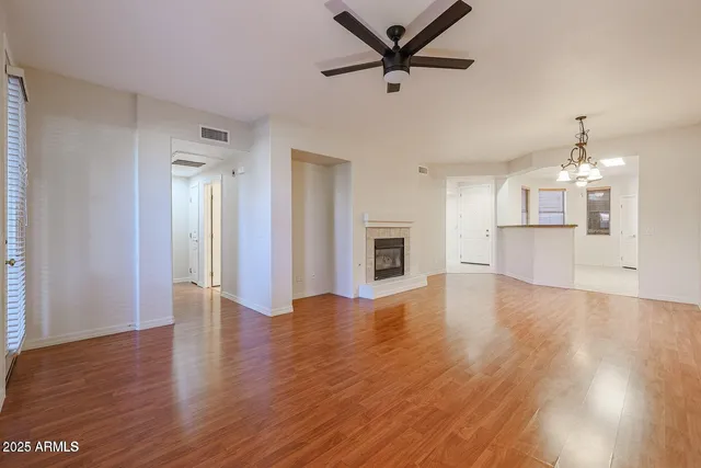 a view of a big room with wooden floor and a kitchen