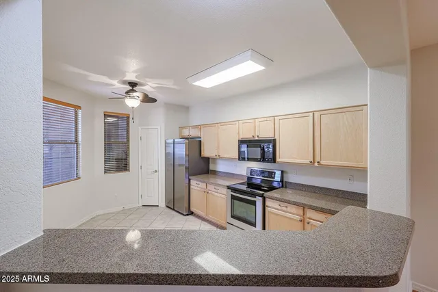 a kitchen with stainless steel appliances granite countertop a stove refrigerator and microwave